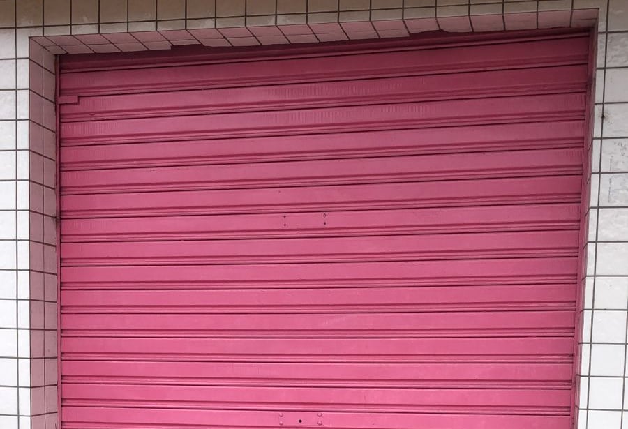 Fachada de loja com porta de enrolar em manutenção