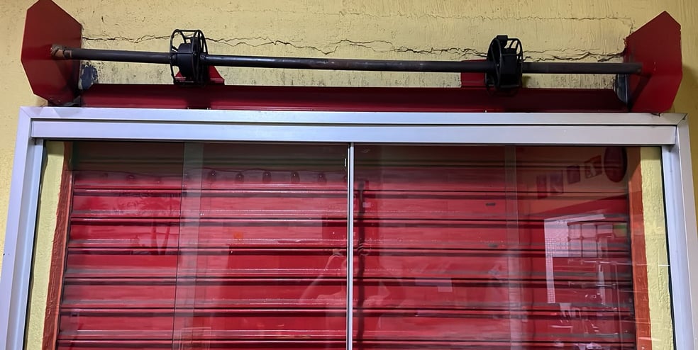 Técnico realizando manutenção em motor de porta de enrolar